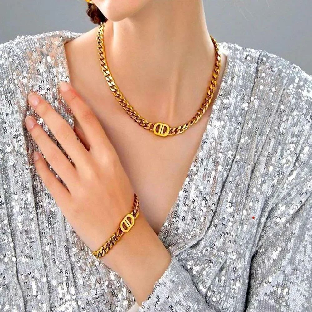 18k gold-plated chain necklace and bracelet set featuring a "DD" logo charm.
